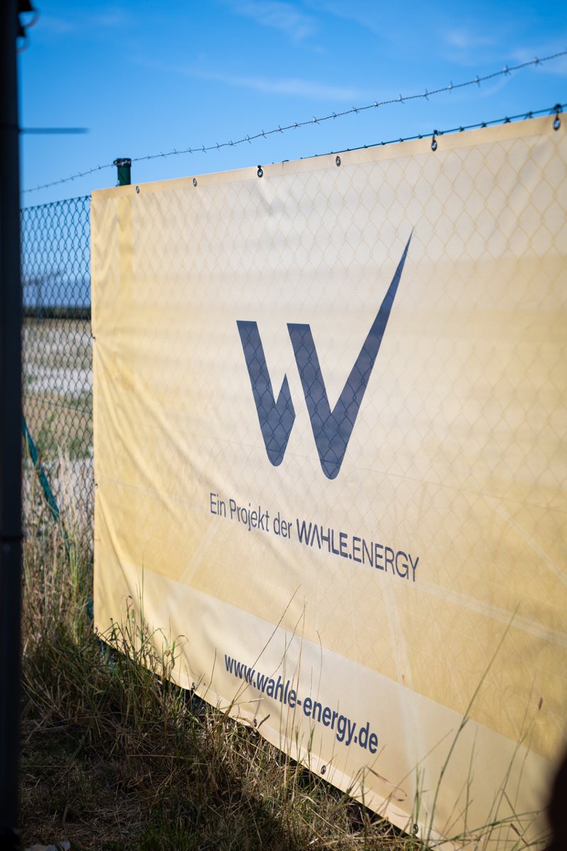 Banner „Ein Projekt der Wahle Energy“ am Zaun des Solarparks